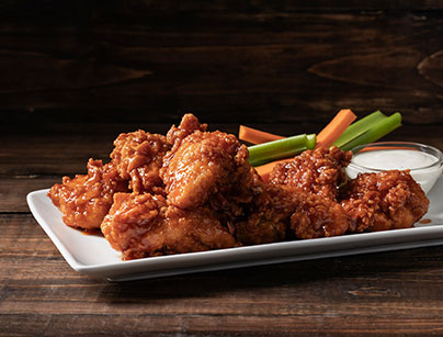 Boneless wings on a plate with carrots and celery