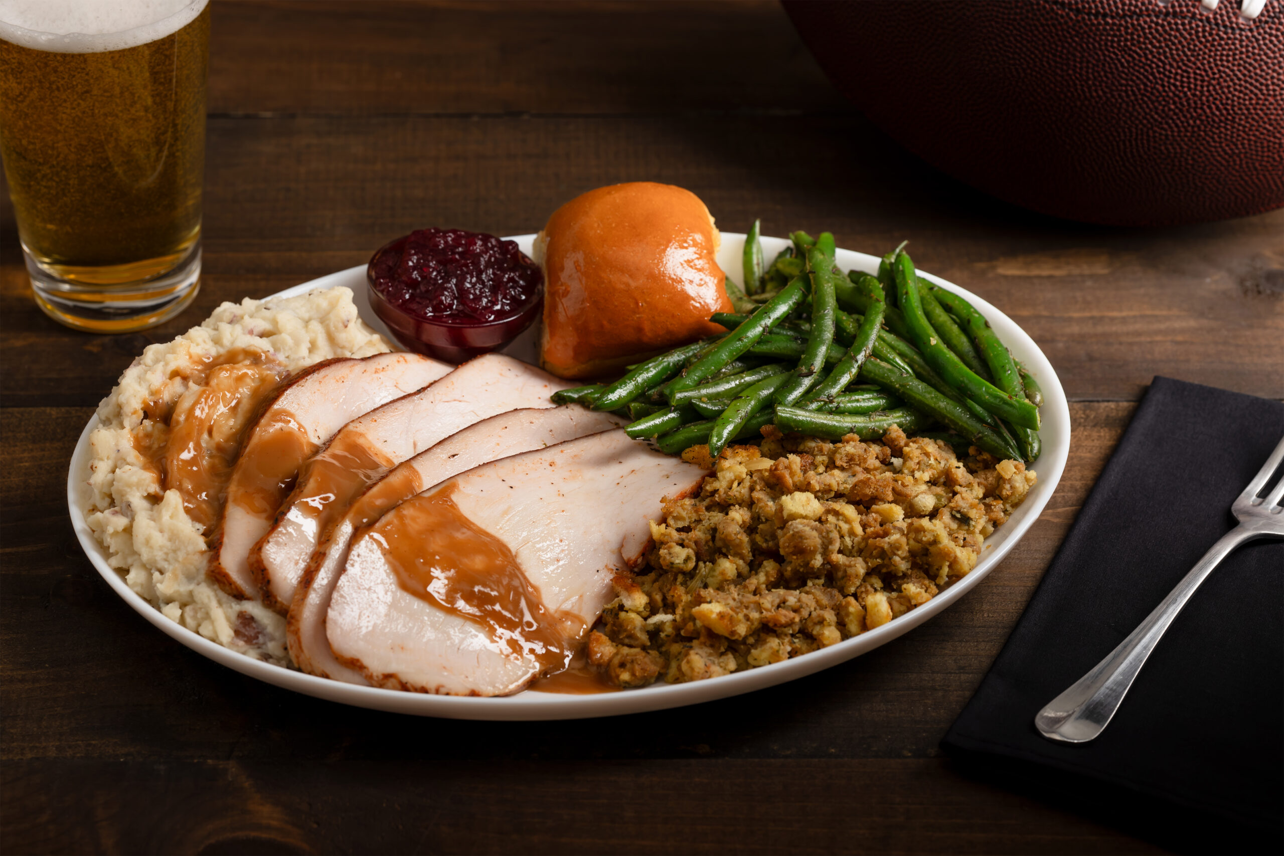 Thanksgiving plate with turkey, stuffing, green beans, mashed potatoes and gravy